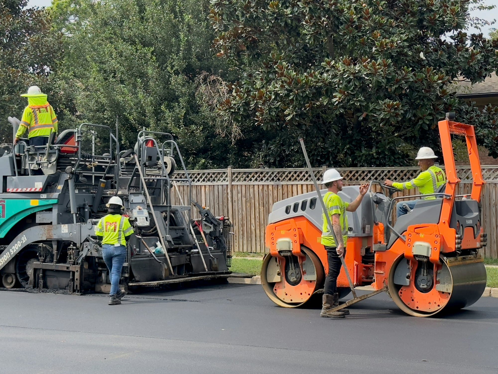 Équipe de travaux publics et finisseur d'enrobé sur un chantier de voirie