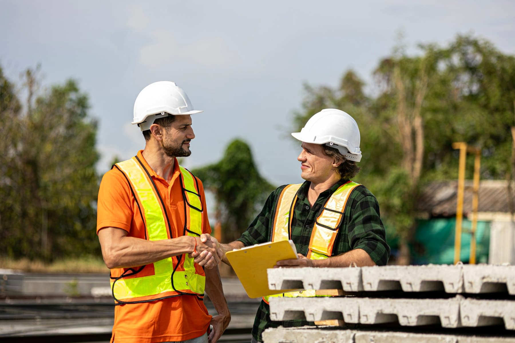 Deux professionnels du bâtiment se serrant la main sur un chantier